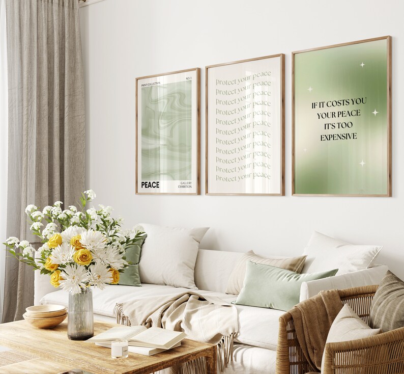 Pode incluir: Tr&ecirc;s impress&otilde;es de arte emolduradas com molduras de madeira penduradas acima de um sof&aacute; branco. As impress&otilde;es apresentam texto e designs abstratos em tons de verde e branco. Uma impress&atilde;o diz "PEACE", outra "Protect your peace" e a terceira "If it costs you your peace it's too expensive".