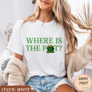 Könnte beinhalten: Weißes T-Shirt mit dem grünen Text "WHERE IS THE POT?", das einen Goldtopf und ein Kleeblatt-Design zeigt. Das Shirt ist ein lässiger Stil, perfekt für St. Patrick's Day.