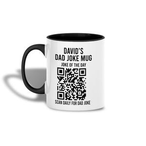 Könnte beinhalten: Ein weißer Keramikbecher mit schwarzem Henkel und schwarzem Innenrand. Auf der Vorderseite befindet sich schwarzer Text mit der Aufschrift DAVID'S DAD JOKE MUG, JOKE OF THE DAY und SCAN DAILY FOR DAD JOKE, zentriert um einen QR-Code.