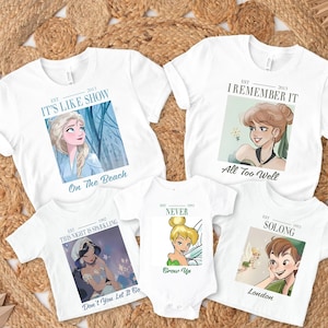 Könnte beinhalten: Weiße T-Shirts mit verschiedenen Cartoon-Charakter-Grafiken. Eines zeigt Elsa mit dem Text "IT'S LIKE SHOW On The Beach". Ein anderes zeigt einen Charakter mit dem Text "I REMEMBER IT All Too Well". Weitere Shirts sind "THIS NIGHT IS SPARKLING", "NEVER Grow Up" und "SOLONG London".