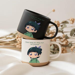 Può includere: Due tazze in ceramica, una nero opaco e una bianco sporco maculato, ciascuna con un personaggio dei cartoni animati con capelli scuri e una veste verde. Sopra il personaggio, il testo recita: "This may or may not be poison."