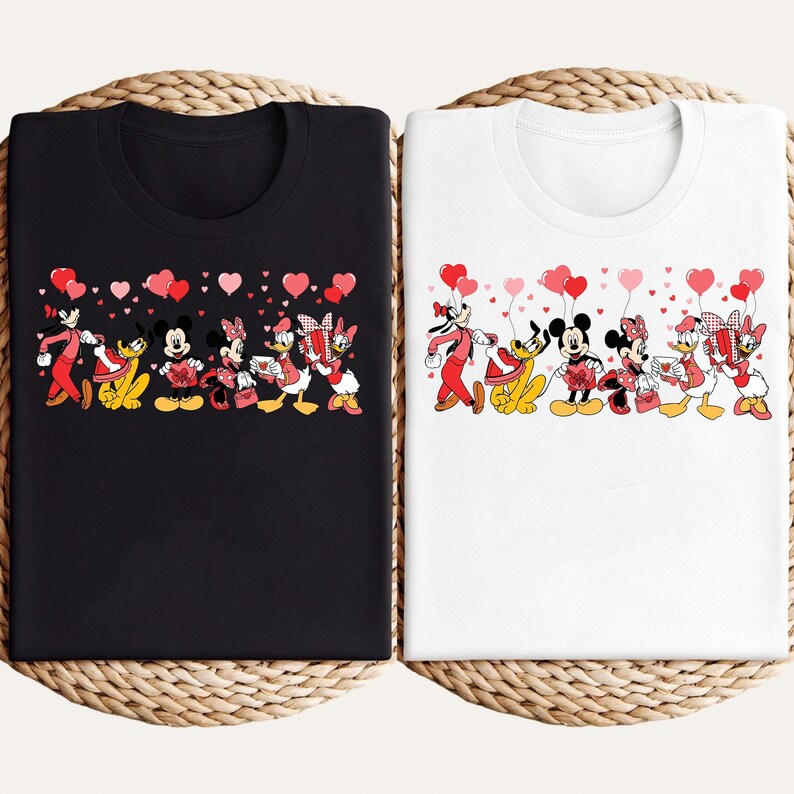 Pu&ograve; includere: T-shirt nere e bianche con un design Disney per San Valentino. La grafica presenta Topolino, Minnie, Paperino, Paperina, Pippo e Pluto, che tengono regali e palloncini a forma di cuore. Il design &egrave; su uno sfondo pieno di cuori.