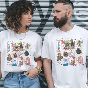 Könnte beinhalten: Weiße T-Shirts mit einem farbenfrohen Grafikdesign mit dem Wort "Zootopia" und Cartoon-Tierfiguren. Die Shirts werden von zwei Personen getragen, wobei das Design prominent auf der Vorderseite zu sehen ist.