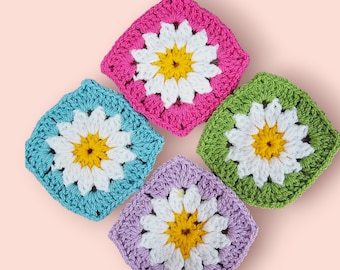 May include: Four crocheted squares with a daisy design in pink, green, blue, and purple.
