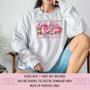 May include: A gray sweatshirt with the text "Just a Girl Who Loves True Crime and Coffee" in pink lettering. The design features four pink coffee cups with various crime-themed decorations, including a skull, a bloody axe, and a heart.