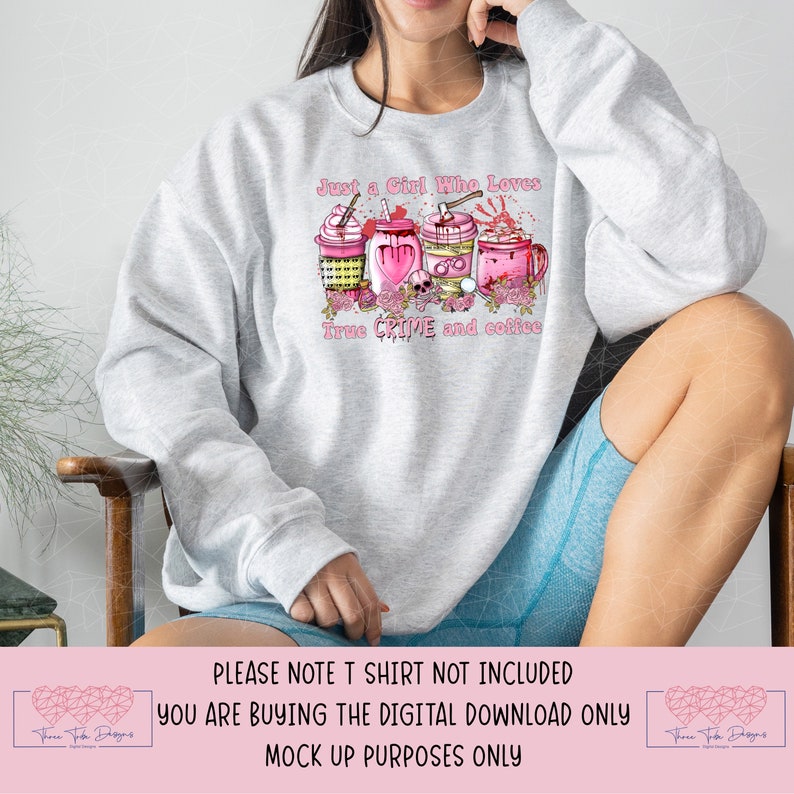 May include: A gray sweatshirt with the text "Just a Girl Who Loves True Crime and Coffee" in pink lettering. The design features four pink coffee cups with various crime-themed decorations, including a skull, a bloody axe, and a heart.