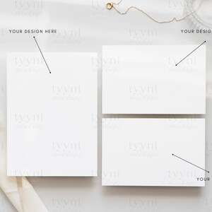May include: Three blank white cards on a light grey surface with a white fabric draped over the left side of the image. The text "YOUR DESIGN HERE" is written on the image above each card.
