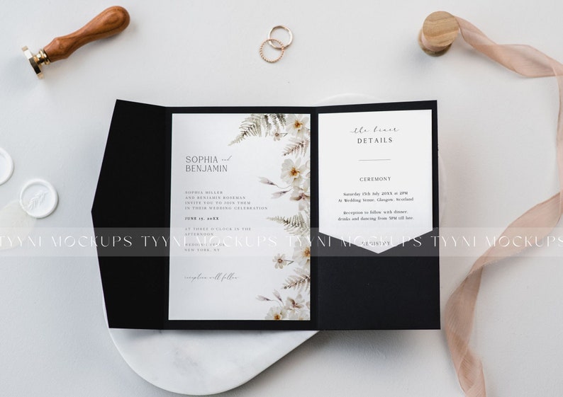 May include: A black wedding invitation suite with floral accents and gold rings. The invitation features the names "Sophia and Benjamin" and event details. A wax seal and ribbon are also present.