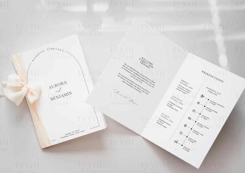 May include: A wedding program booklet with a white cover and a black arch design. The cover reads "Wedding Timeline" and "Aurora and Benjamin". The inside pages include a welcome message and a weekend events timeline.