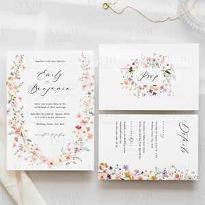 May include: Wedding invitation suite featuring a floral design. The invitation card has a wreath of watercolour flowers in shades of pink, purple and peach. The text reads "Emily & Benjamin" and includes the wedding date and time. The RSVP card features a similar floral design with the word "RSVP". The details card features a floral design and the word "Details".