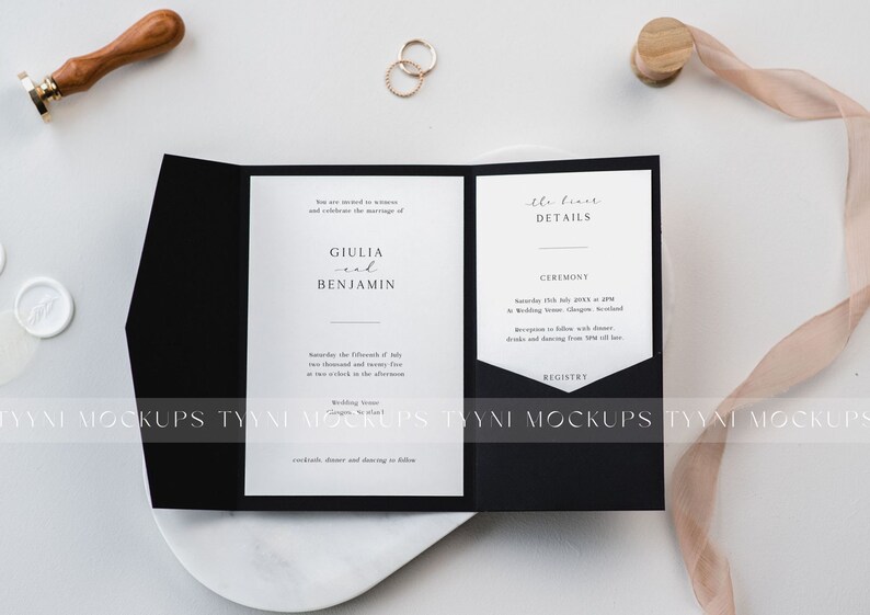 May include: A black and white wedding invitation suite with the names "Giulia and Benjamin" printed on the front. The invitation includes details about the ceremony and reception. A wax seal, rings, and a ribbon are also in the image.