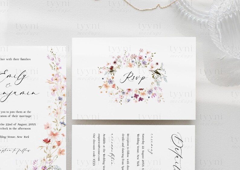 May include: Wedding invitation featuring a floral design. The invitation is for Emily and Benjamin's wedding on 22nd August 20XX at a venue in New York. The RSVP card features a floral wreath with the word "RSVP" in the centre.