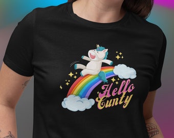 Może przedstawiać: Czarny T-shirt z tęczą i jednorożcem, który na niej jeździ. Tekst "Hello Cunty" jest napisany retro czcionką.