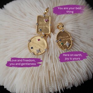 May include: Three gold pendants with colorful gemstones and inspirational messages. The pendants are on a white coral-like surface. The text on the pendants reads: "You are your best thing", "Here on earth joy is yours", and "Love and freedom, you and gentleness". The text "LIGHT VERSE MELBOURNE" is at the bottom of the image.