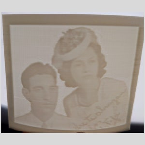 May include: A black and white photograph of a couple. The woman is wearing a hat and the man is wearing a suit. The photo is printed on a white background and has the text "Just always" written on it.