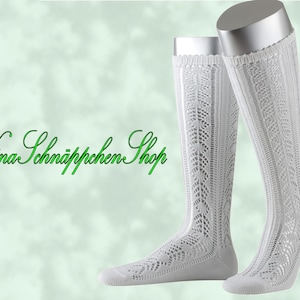 May include: A pair of white knee-high socks with a lacy knit pattern. The socks are displayed on a mannequin.