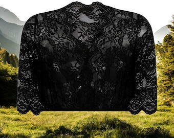 May include: Black lace shrug with a high neckline and three-quarter sleeves. The shrug is made of delicate lace and has a scalloped edge.