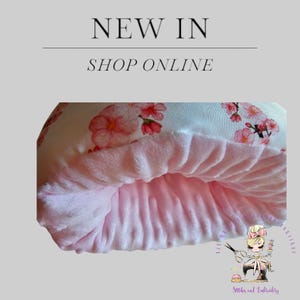 Könnte beinhalten: Ein rosa-weißes Kissen mit Blumenmuster. Das Kissen ist aus weichem Stoff und hat ein flauschiges rosa Futter. Das Kissen ist perfekt zum Kuscheln auf der Couch oder im Bett.