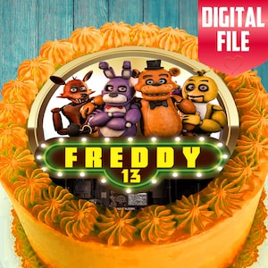 May include: A digital file featuring a cake design with the text "FREDDY 13" and cartoon characters. The cake has orange frosting and decorative swirls. The words "DIGITAL FILE" are in a red banner.