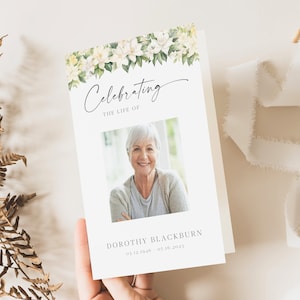 May include: A white funeral order of service with a floral border of white flowers and green leaves. The text "Celebrating the Life of" is at the top of the order of service. A photo of a woman is in the centre of the order of service. The text "Dorothy Blackburn 03.12.1946 - 07.16.2023" is at the bottom of the order of service.