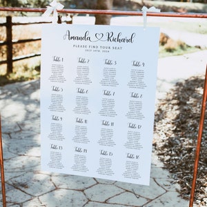 May include: A white seating chart with black text for a wedding reception. The chart is titled "Amanda & Richard" with the date "July 14th, 2024". The chart lists 16 tables with guest names.