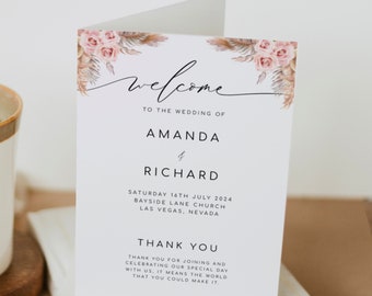 May include: A wedding welcome sign with a floral design featuring pink roses and dried pampas grass. The sign reads "Welcome to the wedding of Amanda & Richard, Saturday 16th July 2024, Bayside Lane Church, Las Vegas, Nevada. Thank you for joining and celebrating our special day with us, it means the world that you could make it."