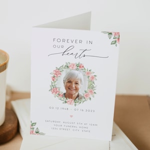 May include: A white card with a floral wreath and a photo of a woman. The text reads "Forever in our hearts" and includes the dates "03 12 1948 - 07 16 2023". The card also includes the text "Saturday, August 5th at 10am, Your Funeral Home, 1234 Street City State."