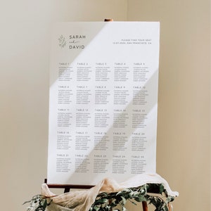 May include: A white seating chart with the names "Sarah and David" at the top. The chart lists tables 1 through 25 with guest names at each table. The text "Please find your seat" and "12.07.2024, San Francisco, CA" is at the top of the chart.