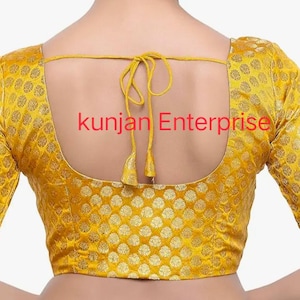 以下が含まれることがあります： 黄色いブロードのブラウスで、背中は低く、リボンで結ぶことができます。ブラウスには、小さな金色の円が繰り返し描かれた模様があります。ブラウスの後ろには、「kunjan Enterprise」という文字が印刷されています。