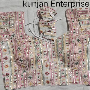 May include: White embroidered blouse with a geometric pattern and sequins. The blouse has a scoop neck and short sleeves. The text "kunjan Enterprise" is visible at the top of the image.