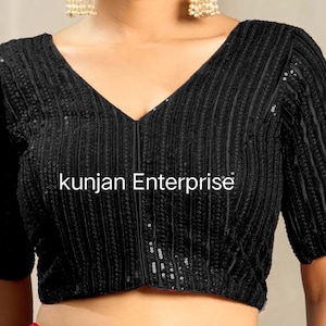 Könnte beinhalten: Ein schwarzes, paillettenbesetztes Crop-Top mit V-Ausschnitt und kurzen Ärmeln. Das Top hat eine vertikale Rippenstruktur und der Text "kunjan Enterprise" ist auf der Vorderseite aufgedruckt.