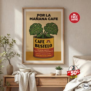May include: A framed wall art print featuring a graphic illustration of a Cafe Bustelo coffee can with a monstera plant growing out of the top. The text reads POR LA MA&Ntilde;ANA CAFE, CAFE BUSTELO, SIEMPRE FRESCO, PURO Y AROMATICO COMO NINGUNO, PESO NETO 10 OZ. (283G).