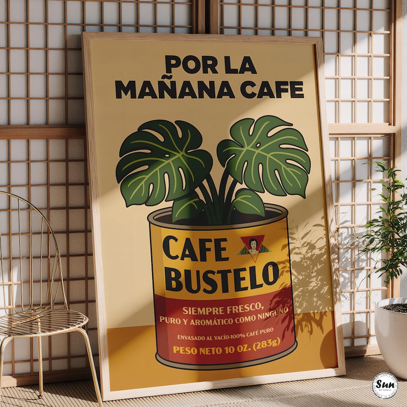 May include: A framed poster featuring a yellow background with the text POR LA MA&Ntilde;ANA CAFE at the top. A green monstera plant grows out of a yellow and red Cafe Bustelo coffee can. The can displays the text CAFE BUSTELO, SIEMPRE FRESCO, PURO Y AROM&Aacute;TICO COMO NINGUNO, and PESO NETO 10 OZ. (283G).