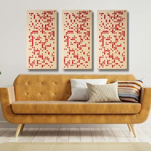May include: Three abstract art pieces with a white background and red geometric shapes. The art pieces are hanging on a white wall above a brown couch.
