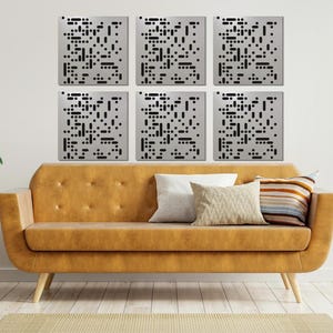 May include: Six square, silver-colored wall panels with a black dot pattern are mounted on a white wall above a mustard-colored sofa. The room is decorated with plants and pillows, creating a modern living space.