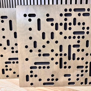 May include: Two brown wood acoustic panels with a random pattern of small and large holes. The panels are made of wood and have a natural finish.
