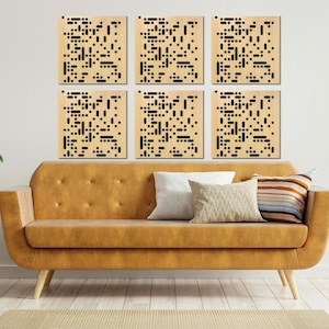May include: Six square wall panels with a geometric pattern of black squares on a light wood background. The panels are arranged in two rows of three, and are displayed on a white wall above a brown couch.