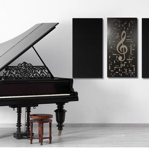 May include: A black grand piano with the lid open, a music stand with a lyre design, and three black framed wall panels with a gold treble clef design.