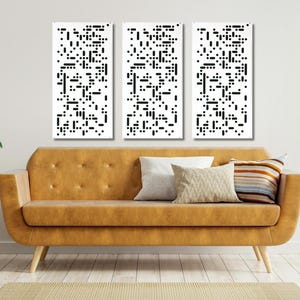 May include: Three black and white abstract art prints with geometric patterns hang on a white wall above a brown leather couch. The couch has a tufted design and is in a living room setting.