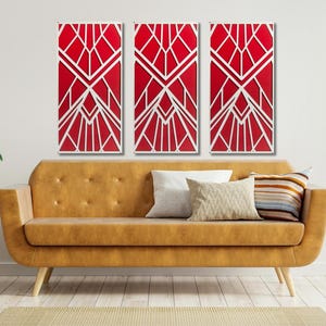 May include: Three red and white geometric wall art panels with a modern design. The panels are hanging on a white wall above a brown leather couch.