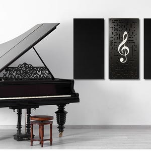 May include: A black grand piano with the lid open, a music stand with a lyre, and three black framed wall panels with a white treble clef design.