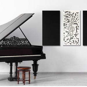 May include: A black grand piano with the lid open, sitting in a room with white walls. There are three black acoustic panels on the wall behind the piano, one of which has a treble clef graphic. A gold music stand is in the corner of the room.