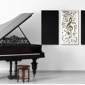 May include: A black grand piano with an open lid, a music stand with a lyre design, and three acoustic panels on a white wall. The center panel features a treble clef graphic.