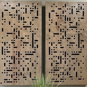 May include: Two wooden panels with a geometric pattern of holes and lines. The panels are light brown with a wood grain pattern. The holes are arranged in a random pattern and are of different sizes. The lines are also arranged in a random pattern and are of different lengths.