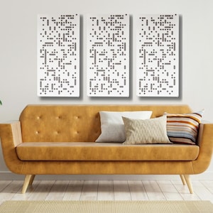 May include: Three white rectangular wall panels with a geometric pattern of small gray squares. The panels are hanging on a white wall above a brown leather sofa with pillows.