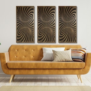 May include: Three abstract wall art panels with a swirling black and gold pattern. The panels are hanging on a white wall above a brown couch.