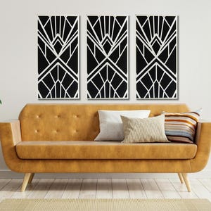May include: Three black and white geometric art prints with a modern design. The prints are hung on a white wall above a brown leather couch with pillows.