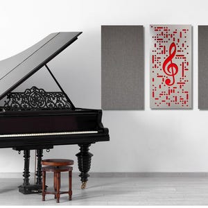 May include: A black grand piano with the lid open, a music stand with a lyre, and three acoustic panels on the wall. The center panel features a red treble clef graphic.