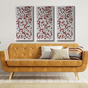 May include: Three abstract wall art panels with a white background and red geometric patterns. The panels are hanging on a white wall above a brown couch.