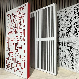 May include: Three white acoustic panels with different patterns. The panel on the left has a red border and a pattern of small circles and lines. The middle panel has a pattern of vertical lines. The panel on the right has a pattern of small circles.
